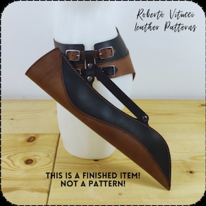 May include: A brown and black leather quiver with decorative stitching detail. The quiver is attached to a brown leather belt with two buckles. The text "This is a finished item! Not a pattern!" is printed below the quiver.