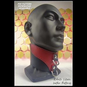 Puede incluir: Un collar de cuero negro con ribete de cuero rojo y dos anillos plateados. El collar está en una cabeza de maniquí sobre un fondo de panal de abeja dorado. El texto "PDF PATTERN DOWNLOAD AVAILABLE" está en la parte superior de la imagen. El texto "Roberto Vitucci Leather Patterns" está en la parte inferior de la imagen.