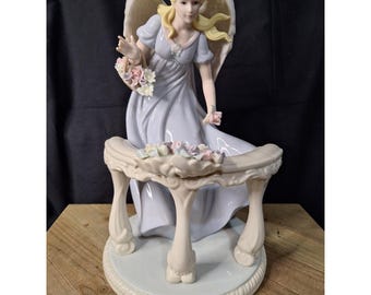 Figura de ángel de porcelana Members Mark con flores y balaustrada, vestido azul.