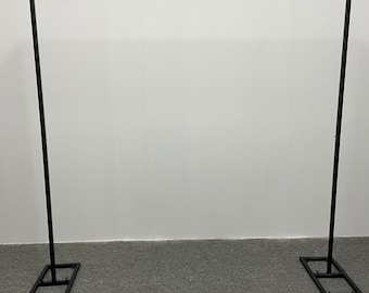 May include: Black metal archway stand with adjustable height. The stand is made of sturdy metal and is perfect for displaying flowers, balloons, or other decorations.