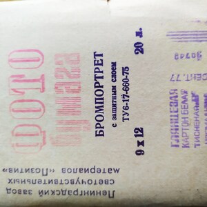 Może przedstawiać: Zabytkowe opakowanie papieru fotograficznego "DOTO", z tekstem cyrylicą i słowami "BROMPORTRET" i "9 x 12". Opakowanie jest w kolorze złamanej bieli z r&oacute;żowym i fioletowym tekstem i zawiera szczeg&oacute;ły techniczne.