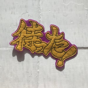 May include: A purple felt patch with the Chinese characters for "Forever Young" embroidered in gold thread.