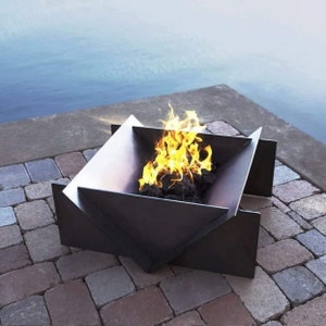 May include: A modern, geometric fire pit with a burning fire. The metal fire pit is dark gray and sits on a brick patio. The flames are bright yellow and orange, contrasting with the dark charcoal within.