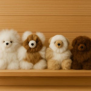 May include: Four plush animal toys in a row, each with a unique design. The toys are white, brown, and tan, with black eyes and noses. They are sitting on a wooden surface against a wooden background.