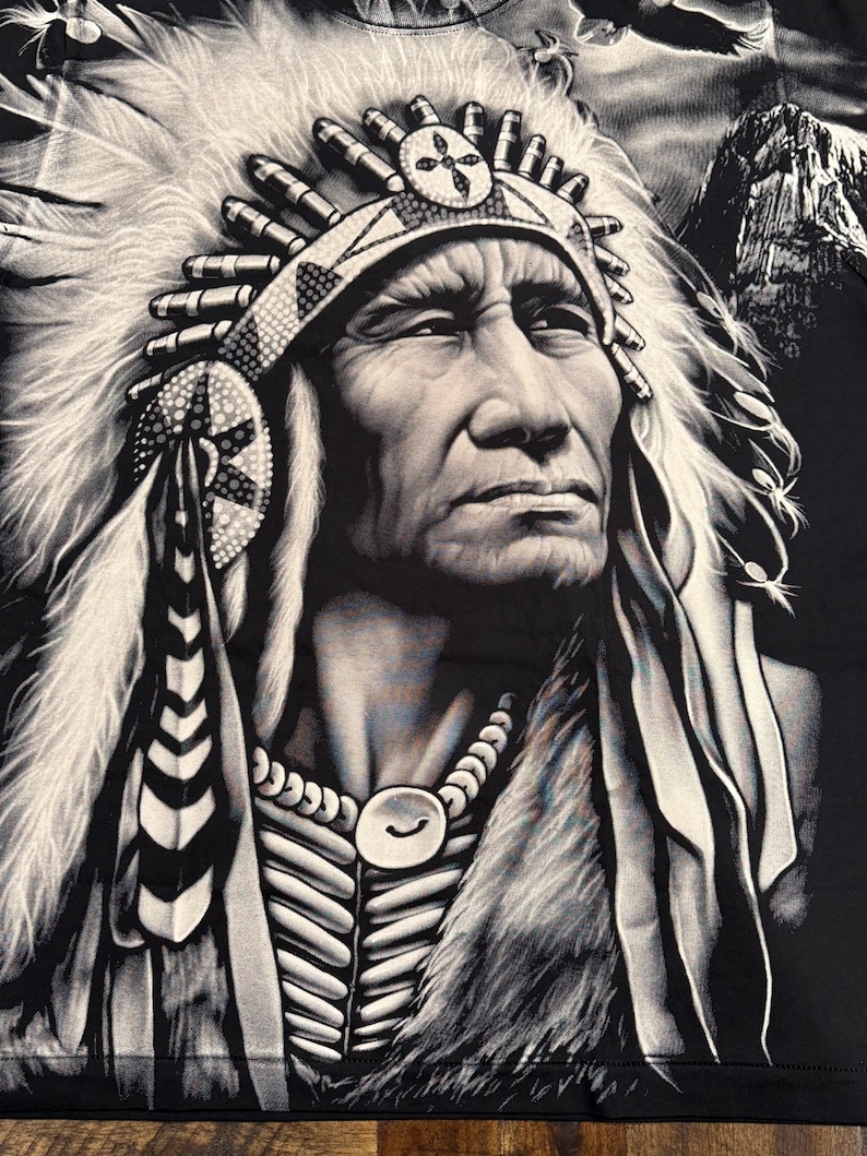 May include: Black and white illustration of a Native American man wearing a headdress with feathers. He is wearing a beaded necklace and has a serious expression on his face.