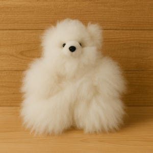 May include: A fluffy, white teddy bear with a round body and small black eyes. The bear is made of soft, plush material and has a friendly, inviting appearance. The toy is a classic children's item.