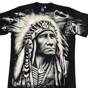 May include: Black t-shirt with a white graphic print of a Native American chief wearing a headdress. The chief is looking to the right and has a serious expression on his face. The background of the image is a mountain range with a bald eagle flying overhead.