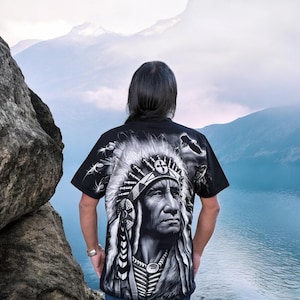 May include: A black t-shirt with a graphic print of a Native American chief wearing a headdress. The chief's face is detailed and the headdress is adorned with feathers.