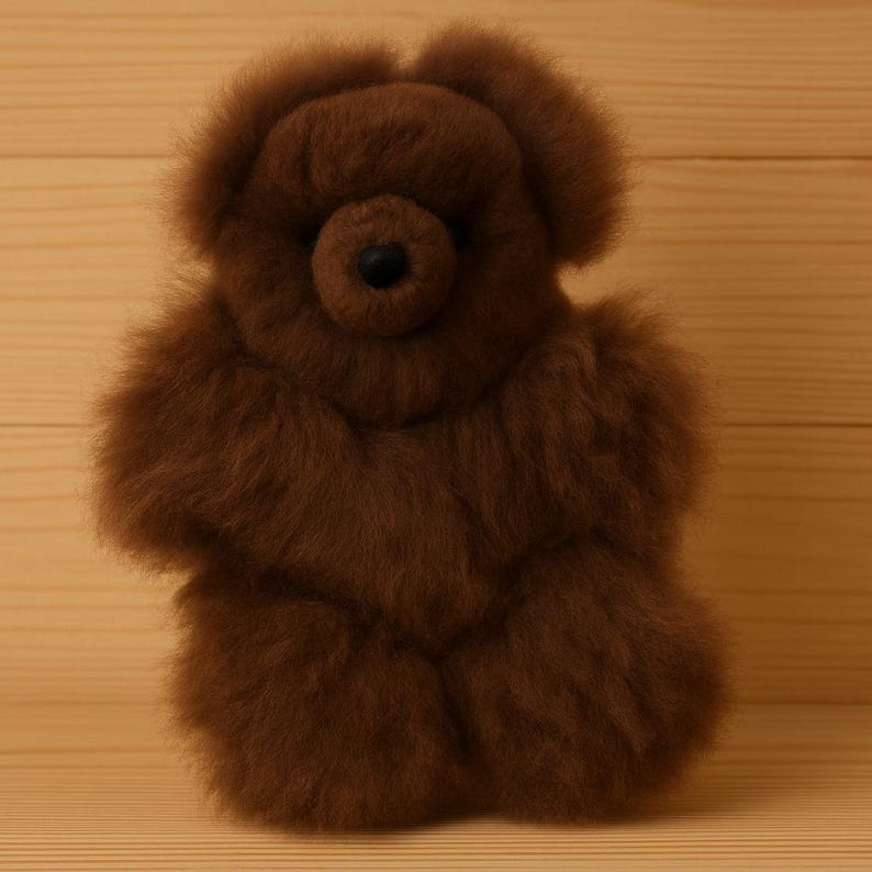 May include: A brown teddy bear made of soft, fluffy material. The bear has a round head, small ears, and a black button nose. Its arms and legs are short and stubby, giving it a cuddly appearance. The bear is a classic toy.