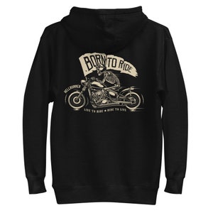 以下が含まれることがあります： ジッパーとフード付きの黒いパーカー。骸骨がバイクに乗っているグラフィックがプリントされています。グラフィックには「Born to Ride」と「Hellrunner」の文字と、その下に「Live to Ride * Ride to Live」の文字が書かれています。