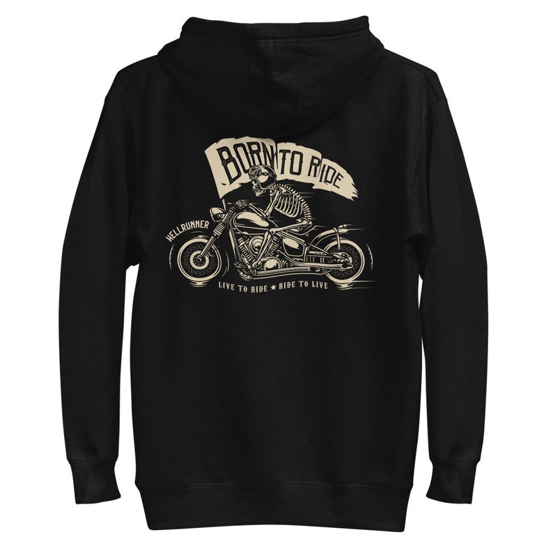 以下が含まれることがあります： ジッパーとフード付きの黒いパーカー。骸骨がバイクに乗っているグラフィックがプリントされています。グラフィックには「Born to Ride」と「Hellrunner」の文字と、その下に「Live to Ride * Ride to Live」の文字が書かれています。