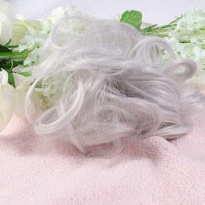 May include: A silver gray hair bun extension. The hair is soft and fluffy, and it is perfect for adding volume and length to your hair.