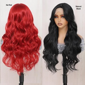 May include: Two long wavy wigs on mannequin heads. The wig on the left is hot red and the wig on the right is natural black.