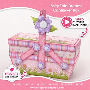 May include: A pink and floral cantilever box with a large purple flower on top. The box has a decorative design with flowers and stripes. Text on the box reads "Fairy Tale Dreams Cantilever Box" and "Video Tutorial Included!"