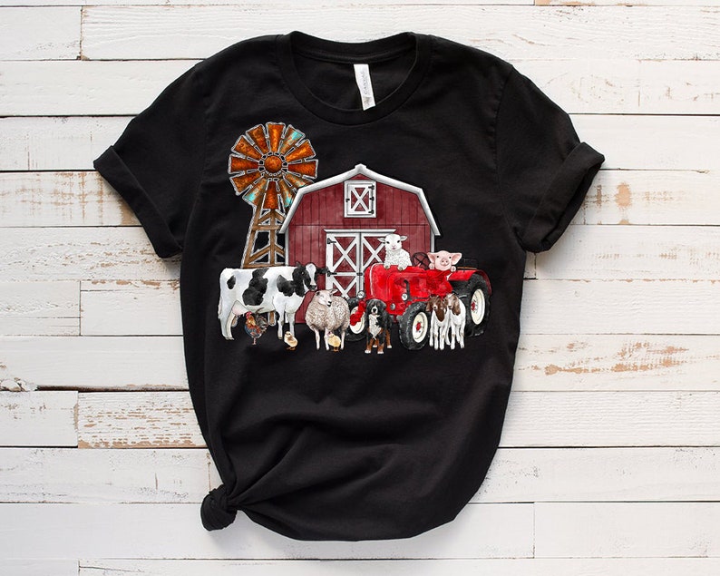 K&ouml;nnte beinhalten: Schwarzes T-Shirt mit einem roten Stall, einer Windm&uuml;hle, einem roten Traktor und Nutztieren. Zu den Tieren geh&ouml;ren eine Kuh, ein Schaf, ein Schwein und ein Hund.