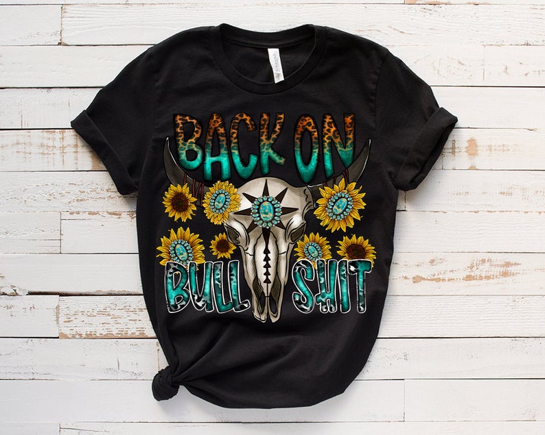 May include: Black t-shirt with a turquoise and white skull design with sunflowers and the text "Back on Bull Shit".