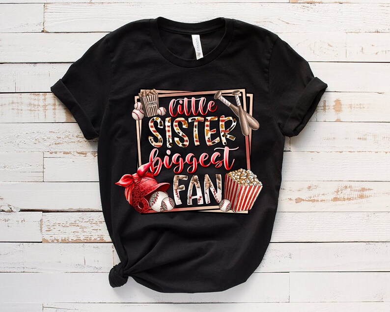 K&ouml;nnte beinhalten: Schwarzes T-Shirt mit einem Grafikdesign im Baseball-Stil. Der Text auf dem Shirt lautet "Little Sister Biggest Fan".