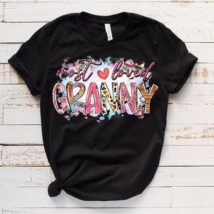 May include: Black t-shirt with a colorful graphic that says "most loved granny" with a pink heart and floral accents.