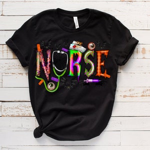 Puede incluir: Camiseta negra con un gr&aacute;fico colorido de la palabra "NURSE" con elementos de tem&aacute;tica de Halloween como un estetoscopio, murci&eacute;lagos y una jeringa.