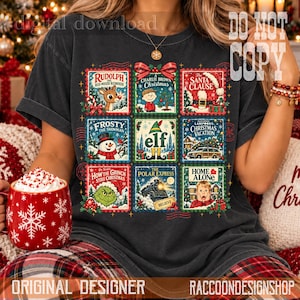 Puede incluir: Una camiseta gris carb&oacute;n con una cuadr&iacute;cula de nueve ilustraciones estilo sello postal que representan pel&iacute;culas navide&ntilde;as cl&aacute;sicas, incluyendo Rudolph el reno de la nariz roja, Charlie Brown, Santa Cl&aacute;usula, Frosty el mu&ntilde;eco de nieve, Elf, Christmas Vacation, El Grinch, El Expreso Polar y Mi pobre angelito.