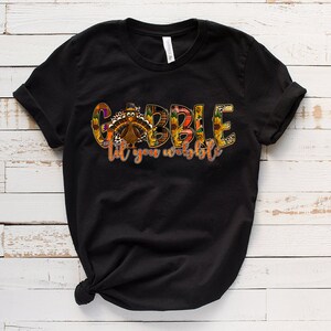 May include: Black t-shirt with a colorful graphic of a turkey and the text "Gobble til you wobble".