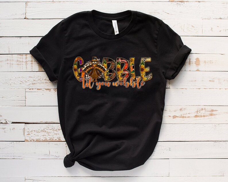 May include: Black t-shirt with a colorful graphic of a turkey and the text "Gobble til you wobble".