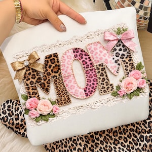 Puede incluir: Un juego de tres tazas de cerámica con un esmalte moteado de color crema. Cada taza presenta un diseño floral pintado a mano en tonos azules, verdes y amarillos. Las tazas tienen una forma simple y moderna.