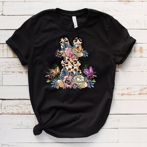 May include: Black t-shirt with a floral design featuring a leopard print bunny rabbit.