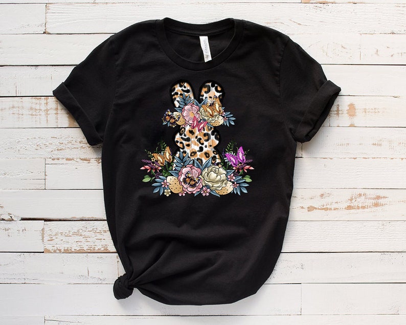 May include: Black t-shirt with a floral design featuring a leopard print bunny rabbit.