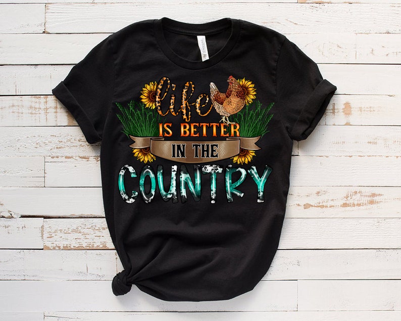 May include: Black t-shirt with a graphic design of a chicken, sunflowers, and the text "Life is better in the country".