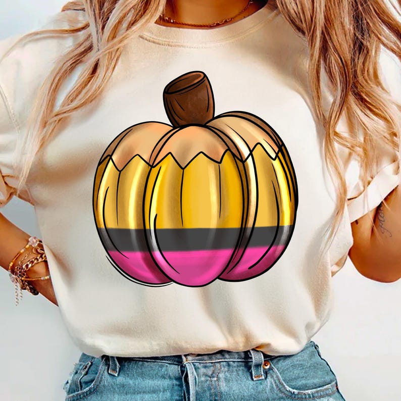 May include: A white t-shirt featuring a graphic of a gold and pink pumpkin with a brown stem.