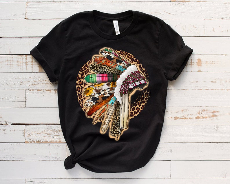 May include: Black t-shirt with a colorful Native American headdress design on a leopard print background.