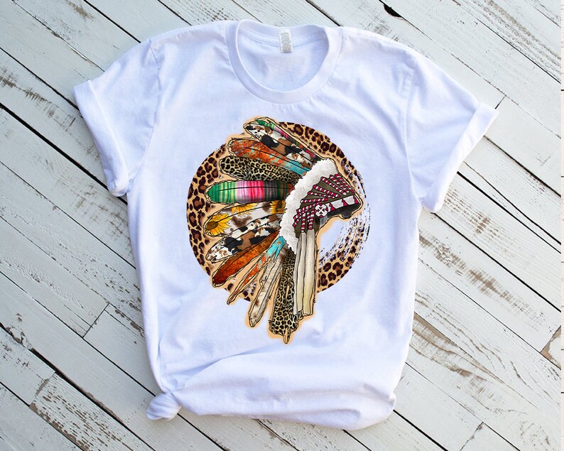 May include: White t-shirt with a colorful Native American headdress design on a leopard print background.