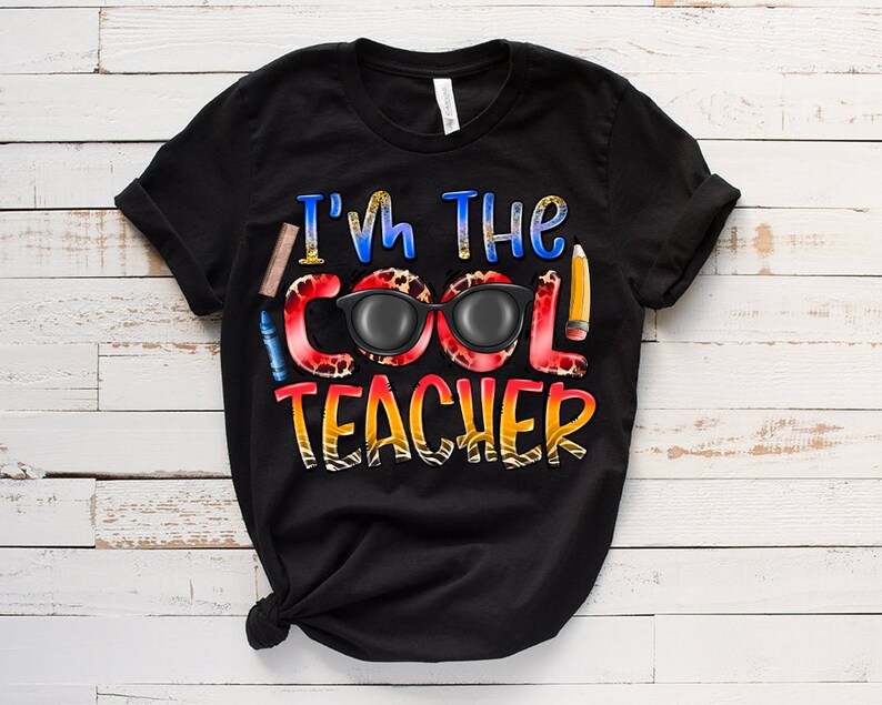 May include: Black t-shirt with the text "I'm the Cool Teacher" in colorful letters with a pair of sunglasses and school supplies.