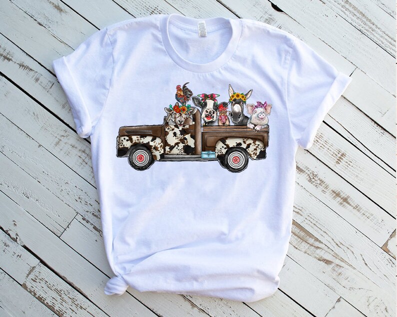 May include: White t-shirt with a graphic of a brown and white pickup truck with a cow, pig, donkey, and chickens in the bed.