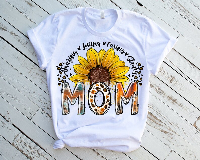 May include: White t-shirt with a sunflower graphic and the text "Amazing Loving Caring Strong Mom".