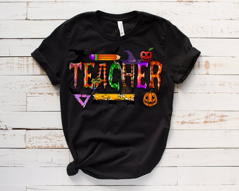 May include: Black t-shirt with a Halloween-themed graphic that says "TEACHER" with a witch's hat, broom, spider, and pumpkins.
