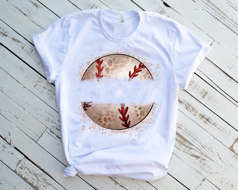 Puede incluir: Camiseta blanca con un gr&aacute;fico de un b&eacute;isbol con un dise&ntilde;o de estampado de leopardo. El b&eacute;isbol est&aacute; rodeado por un efecto de salpicadura blanca.