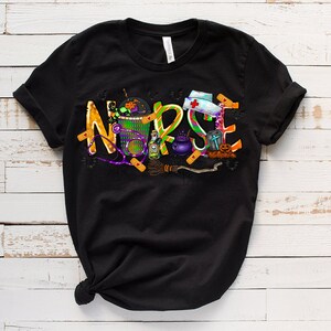 Może przedstawiać: Czarny T-shirt z graficznym wzorem słowa "NURSE" stworzonym z obraz&oacute;w o tematyce Halloween. Wz&oacute;r zawiera kapelusz czarownicy, kocioł, miotłę, stetoskop i bandaż.