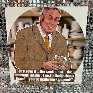 Puede incluir: Un hombre con un traje marrón sostiene una foto enmarcada y dice "Me encanta... el sentimiento... el mensaje dentro... acabo de... (contiene las lágrimas)... me has hecho muy orgulloso!"