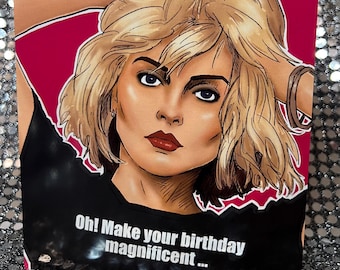 May include: A greeting card featuring a cartoon illustration of a woman with blonde hair and a black shirt. The text on the card reads "Oh! Make your birthday magnificent..."