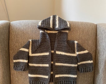 May include: A grey and white striped hooded cardigan with a crocheted texture.