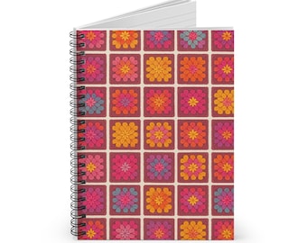 Pode incluir: Caderno espiral com um padrão floral colorido. A capa apresenta uma grelha de quadrados, cada um contendo uma flor estilizada em tons de rosa, laranja, amarelo e azul. O caderno tem um interior branco e uma encadernação em espiral preta.
