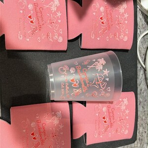 May include: Four pink foam can coolers and one translucent plastic cup, each printed with the text Corina's Bachelorette, Puerto Vallarta, MX, Est. 2020, alongside graphics of a diamond ring, palm trees, sunglasses, a beach chair, and a cocktail.