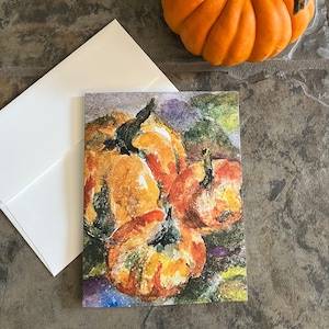 May include: A watercolor painting of a group of orange pumpkins with green stems on a purple background.