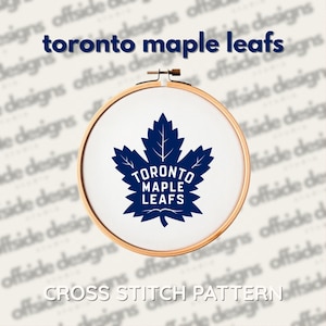 May include: A cross-stitch pattern featuring the Toronto Maple Leafs logo, a blue maple leaf with the team name. The design is displayed in a wooden embroidery hoop. The text "toronto maple leafs" and "CROSS STITCH PATTERN" are also visible.