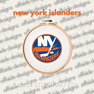 May include: A cross-stitch pattern of the New York Islanders logo, presented in a wooden embroidery hoop. The logo is a circular design with blue, orange, and white elements, including the letters "NY" and the team name. The text "new york islanders" and "CROSS STITCH PATTERN" are also visible.