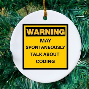 May include: White ceramic ornament with a gold string for hanging. The ornament features a yellow and black warning sign that reads "WARNING MAY SPONTANEOUSLY TALK ABOUT CODING."