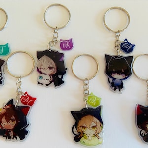 May include: Six colorful anime character keychains with black cat ears. Each keychain features a different character with a unique design and a small charm with a letter on it.