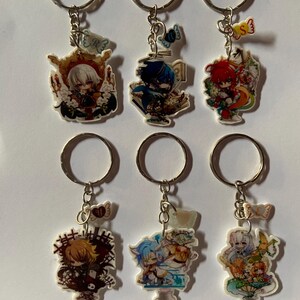 Puede incluir: Seis llaveros de personajes de anime coloridos con anillos de llaves plateados. Cada llavero presenta un personaje diferente con un diseño único y un pequeño amuleto unido al anillo.